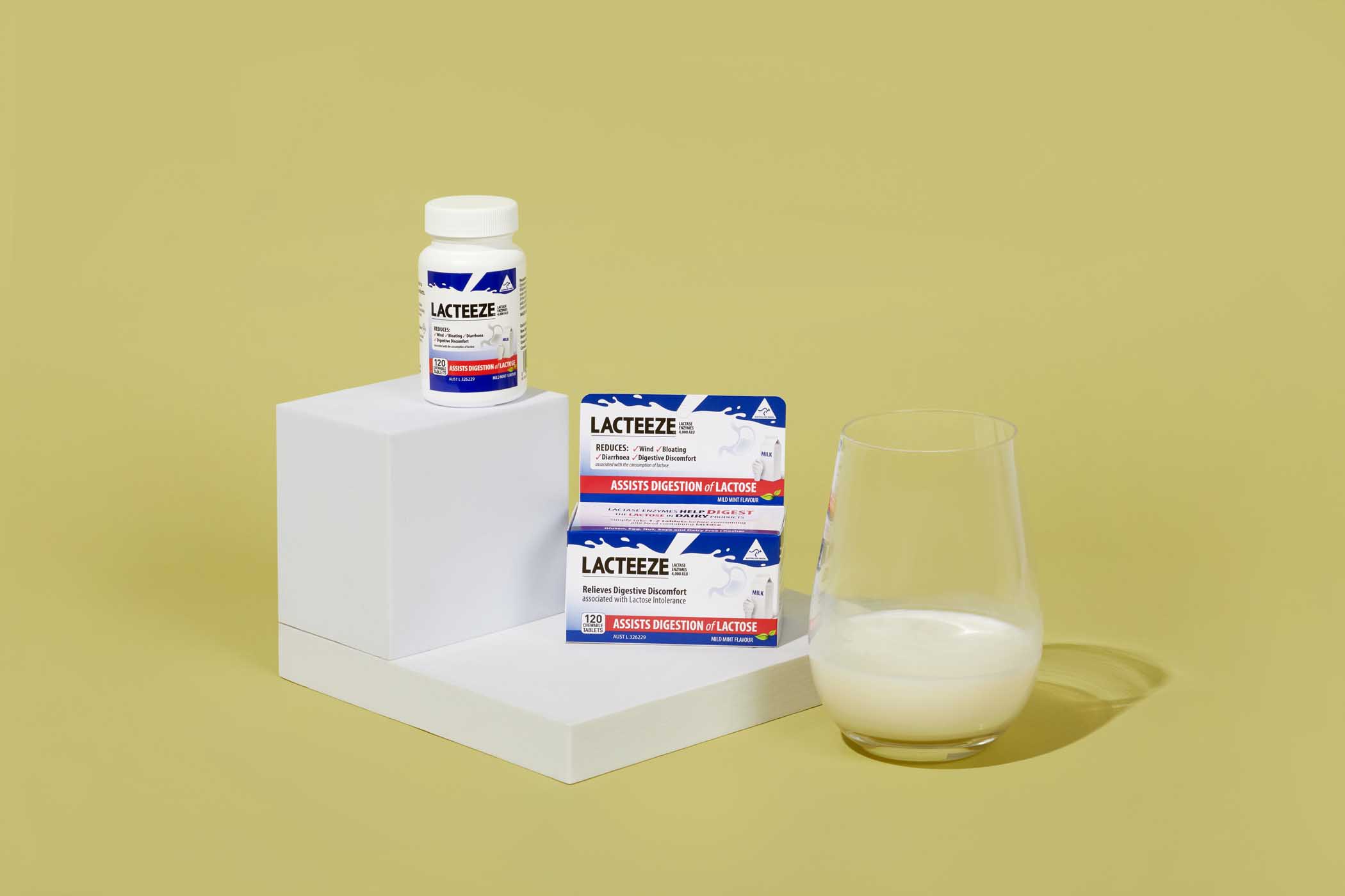 Lacteeze Chewable Tablets beside a Glass of milk