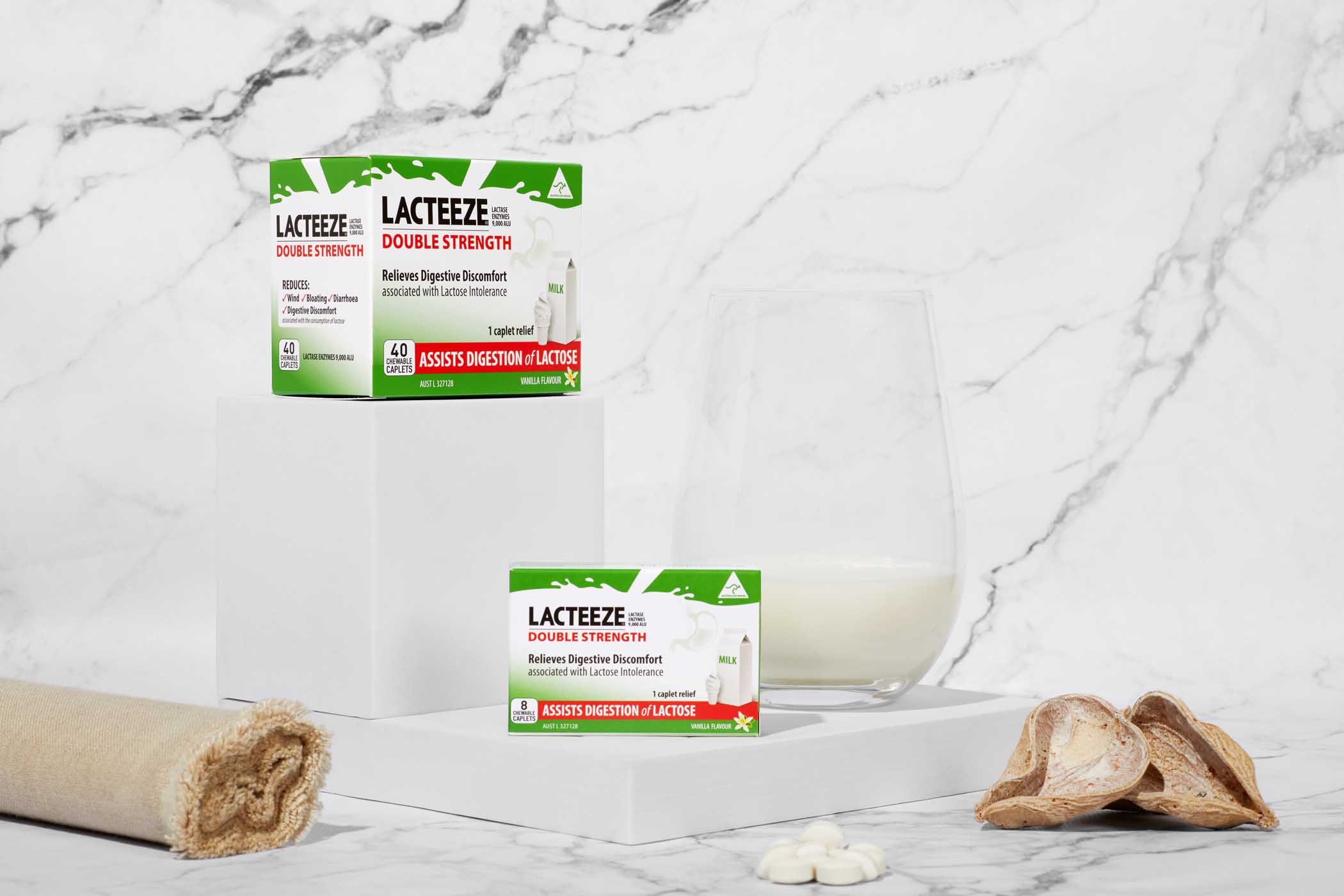 Lacteeze Double Strength Chewable Caplets beside a Glass of milk